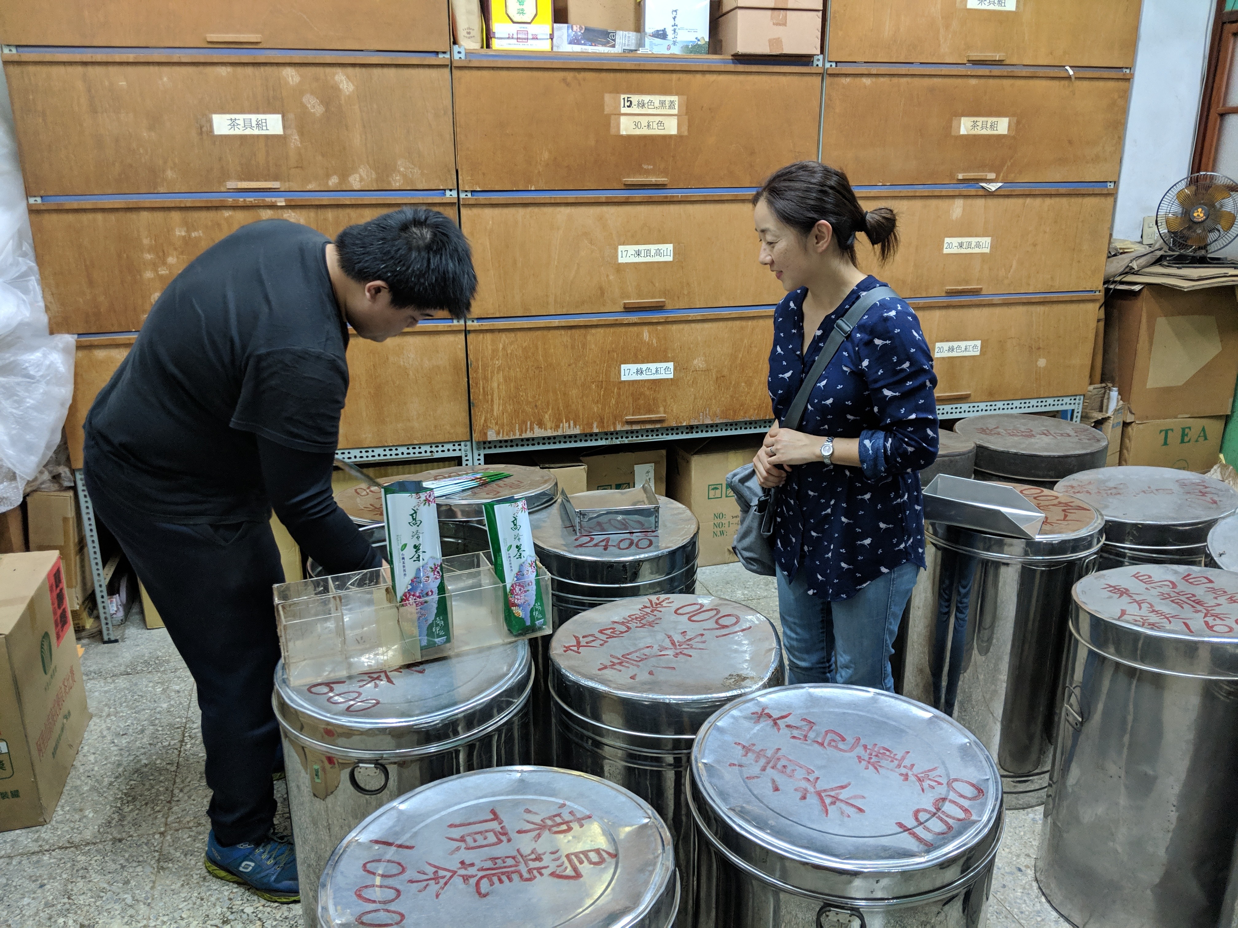 Seri perusing the wares at the tea shop. The handwriting on the drums was incredible.