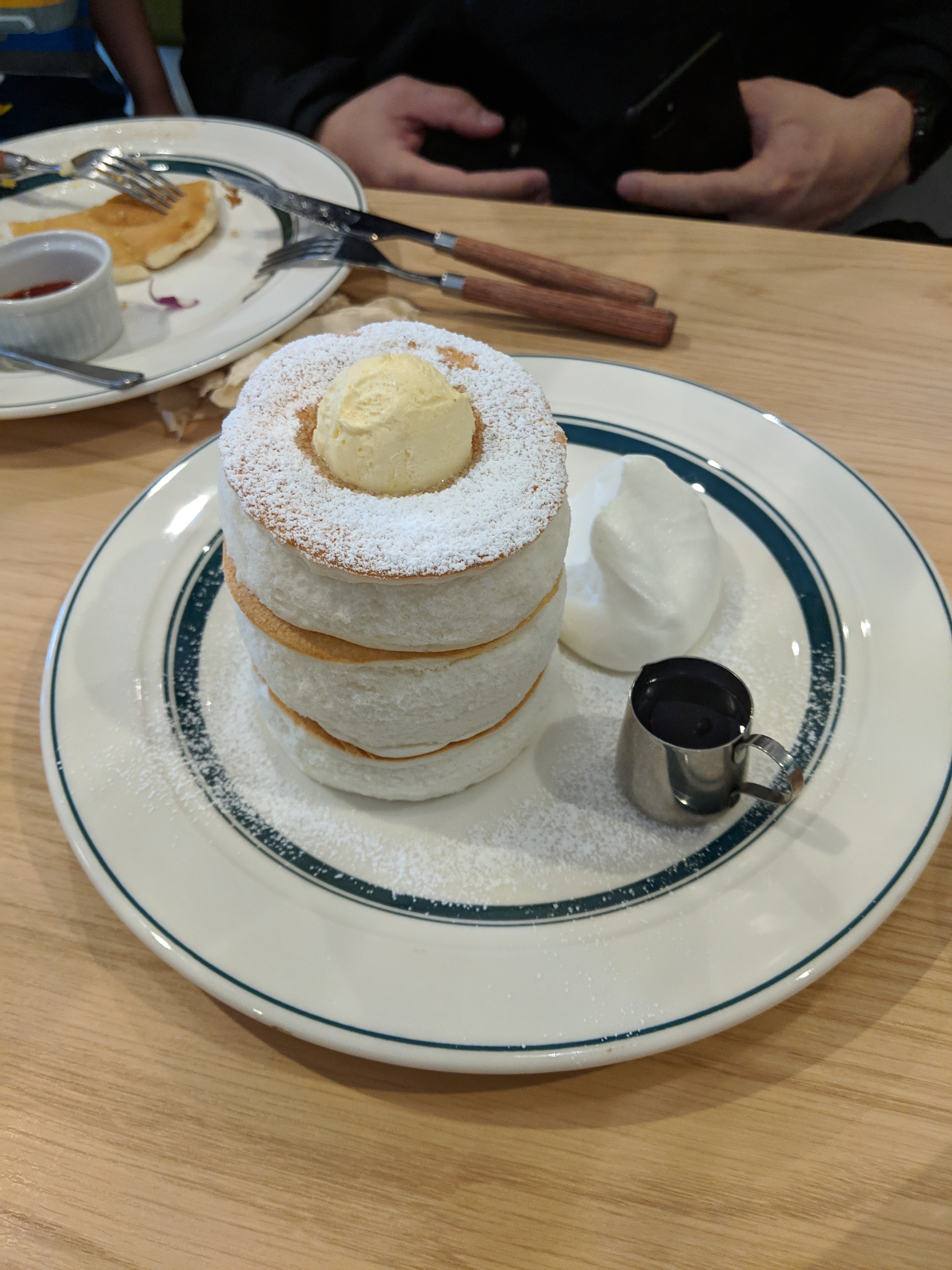 An order of Gram's fluffy pancakes, with a regular pancake in the back for comparison